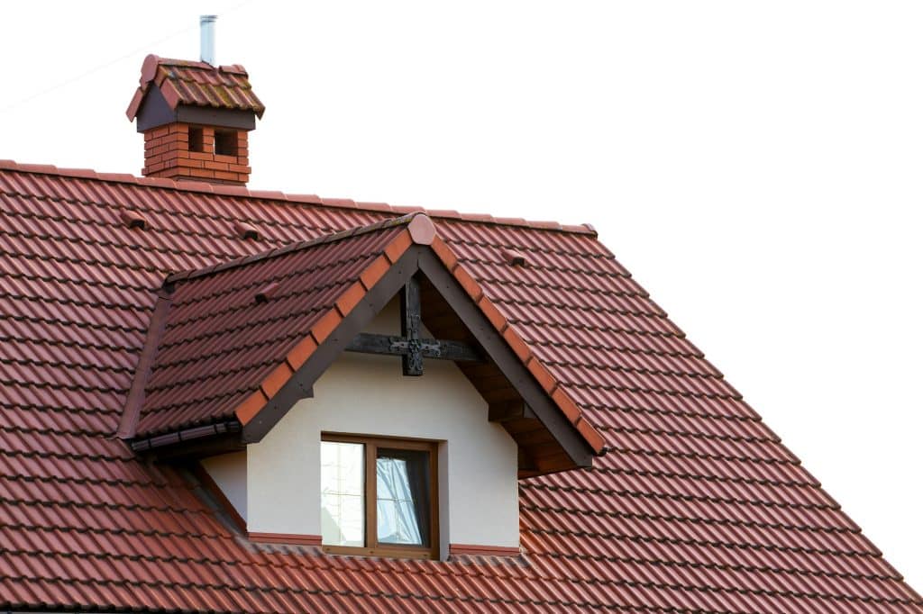 Close up of new orange roof with chimney and small modern window. Concept of modern roof with