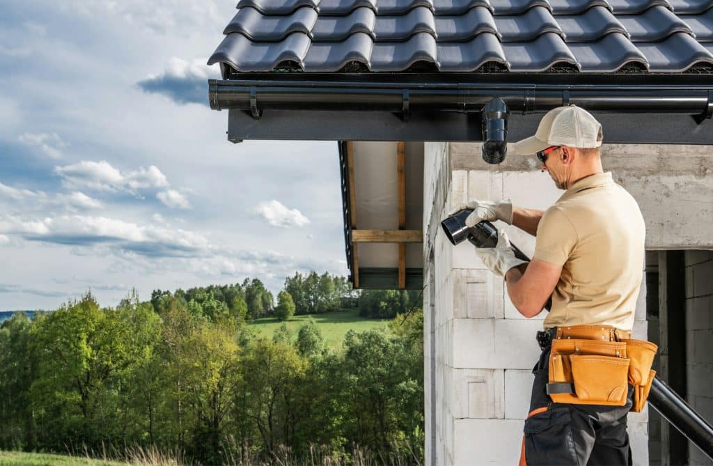 Construction Contractor Roof Worker Installing House Gutters