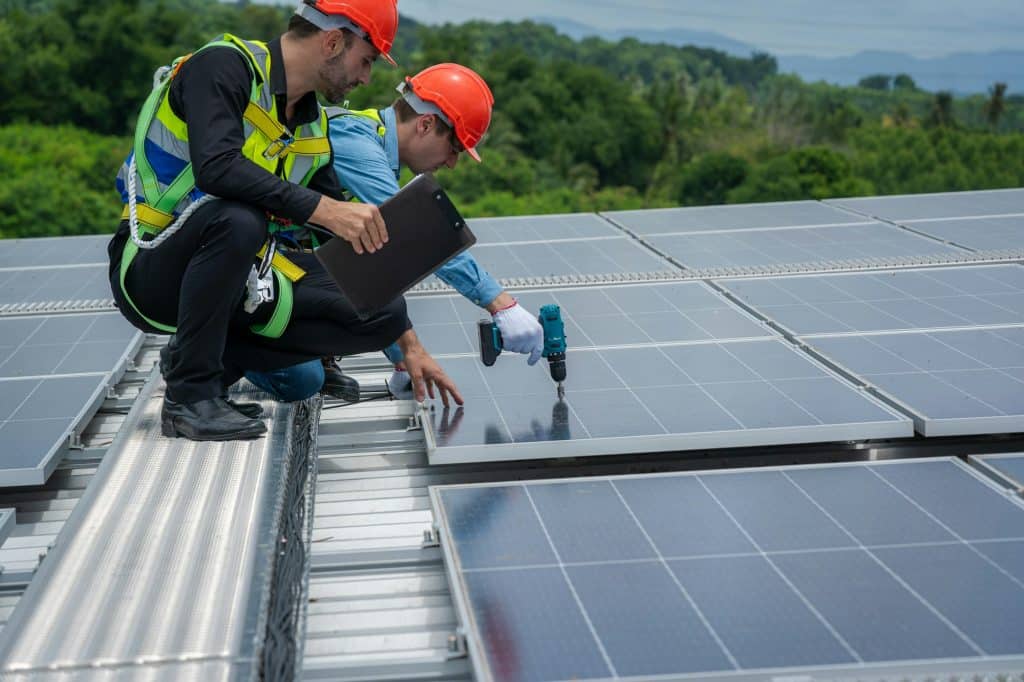 Engineers checking the operation of the system solar cell on roof at factory.