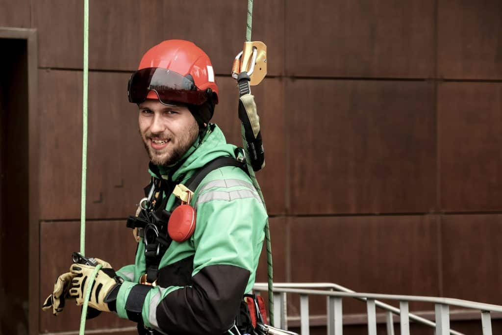 Portrait industrial mountaineering worker in uniform on roof